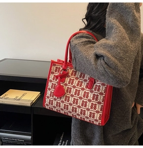 Dettaglio della borsa tote da sposa rossa con motivo tradizionale e ciondolo a cuore