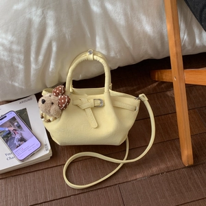 Détail du sac seau plissé jaune avec pendentif ours et bandoulière réglable