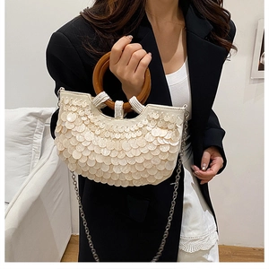 Detail of sequin shoulder bag with wooden ring handle and silver chain strap