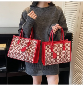 Dettaglio di una borsa tote rossa da sposa con motivi tradizionali portata da una modella