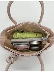 Spacious interior of soft pink tote bag showing storage for phone and cosmetics