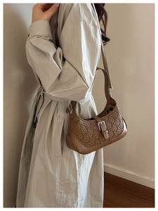 Detailed view of brown retro hobo bag with textured geometric woven pattern and silver buckle