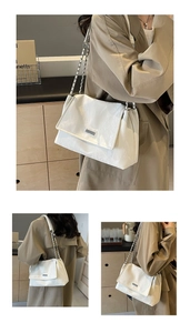 Detail of white marble textured tote bag with silver chain strap and metal logo plate