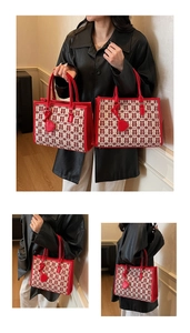 Dettaglio della borsa tote da sposa in jacquard rosso con trama Xi e ciondolo a cuore