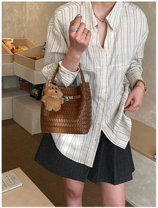 Detailed weave texture on a brown bucket bag with a cute plush bear charm accessory