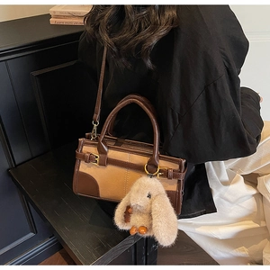 Detail of retro color-block handbag with cute plush rabbit charm and crossbody strap