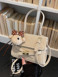 Elegant beige vintage flap underarm bag with gold clasp and cute plush bear charm