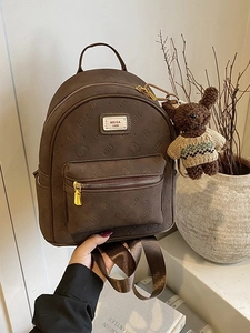 Großer brauner Rucksack im Vintage-Stil mit geprägtem Muster und Plüschbär-Anhänger
