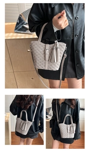 Detailed close-up of cream pleated bucket bag with tassel and adjustable crossbody strap