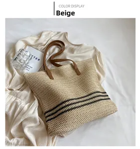 Detail einer geflochtenen Stroh-Tote-Bag in Braun mit schwarzen Streifen und Ledergriffen