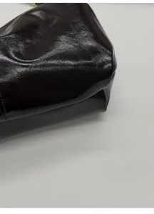 Close-up of the reinforced bottom base on a vintage glossy leather dumpling bag