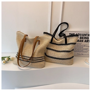 Details der gewebten Stroh-Tote-Bags in Beige mit schwarzen Streifen und Griffen