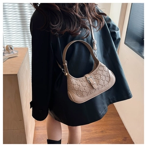 Detail of khaki shoulder bag with wave texture and adjustable buckle on leather jacket