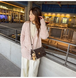 Quilted crossbody bag with chain strap and teddy charm shown in a full autumn outfit