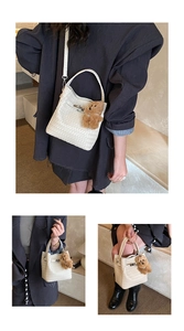 Detail of white woven bucket bag with silver metal buckle and brown plush bear charm