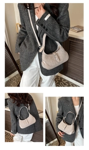 Three-way view of beige faux leather hobo bag with embossed bear pattern and silver hardware