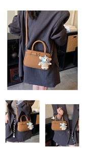 Detailed macro view of brown litchi leather bag with decorative strap and sheep charm