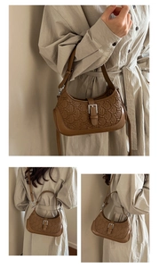 Detail of caramel brown crossbody bag with woven texture and silver buckle accents