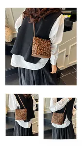Detail of leopard print crossbody bucket bag with brown synthetic leather base and strap