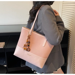Detail of dusty pink tote bag showing suede and PU leather stitching with tassel