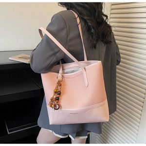 Close-up of pink tote bag showing mixed textures and vintage wooden bead tassel detail