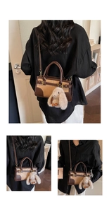 Detail of a vintage-style brown and khaki patchwork handbag with a plush bunny charm