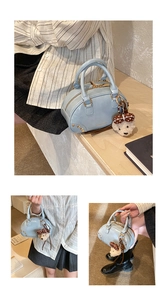Close-up of light blue mini satchel with golden hardware and plush bear charm accessory