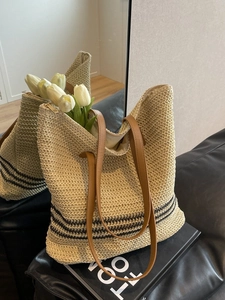 Beigefarbene gewebte Strohtasche mit schwarzen Streifen und braunen Lederriemen