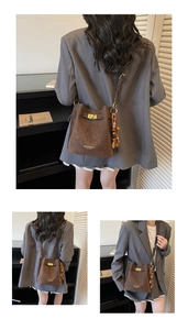 Détail du sac seau marron vintage avec fermoir doré et pompon en perles ethniques
