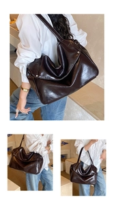 Detail of deep brown glossy tote bag with stylish pleated texture and wide shoulder strap