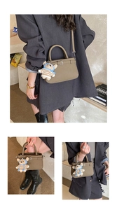 Detail of khaki crossbody bag with adjustable strap and decorative bear charm accessory
