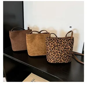 Trois sacs seaux en marron foncé, beige mat et imprimé léopard sur une étagère