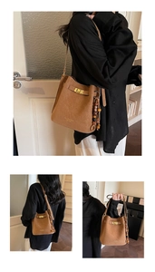 Détail du sac seau en daim marron avec fermoir doré et pendentif en perles de bois ethnique