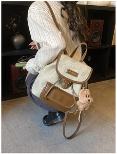 Detail of vintage retro backpack in matte grey-green suede with cute puppy pendant