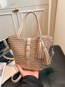 Chic beige pleated bucket bag with tassel detail and adjustable shoulder strap