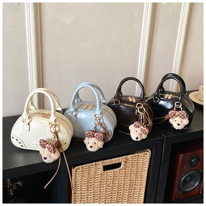 Detailed view of four colorful mini bowling bags on a shelf with plush bear charms