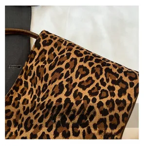 Détail du sac à main léopard avec texture velours et poignée en cuir marron