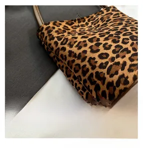 Detail shot of leopard print handbag featuring high-quality stitching and brown leather handle