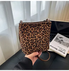 Détail du sac à main léopard en fausse fourrure avec fine bandoulière en cuir
