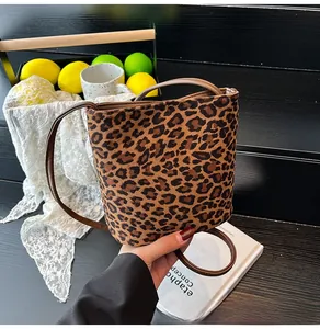 Détail du sac seau à imprimé léopard avec bandoulière en cuir dans un décor vintage