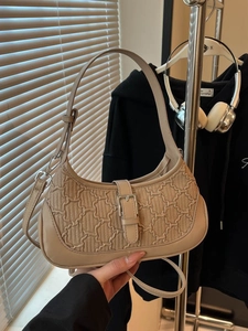Minimalist beige half-moon hobo bag with quilted texture and adjustable strap