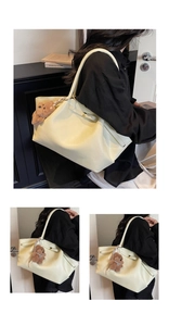 Detail view of large beige tote bag with soft PU leather and brown plush bear charm