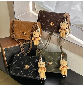 Detailed view of quilted crossbody bags in four colors with bear charms and chain straps