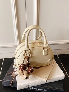 Elegant beige Boston handbag with cute teddy bear charm on books, vintage style purse