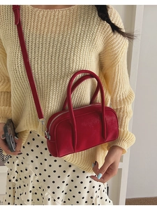 Model wearing a red vintage Boston handbag with silver hardware and long shoulder strap