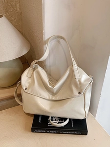 Cream glossy leather tote bag with silver rivets and wide shoulder strap