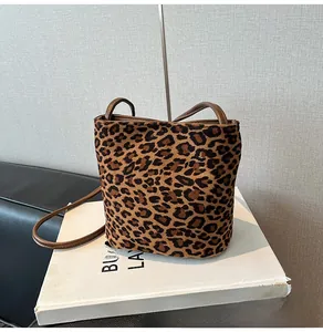 Détail d'un sac seau léopard avec texture mate et fine bandoulière en cuir marron
