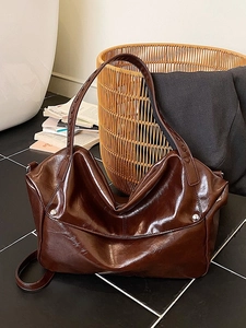 Large dark brown leather tote bag with glossy finish and silver rivet details