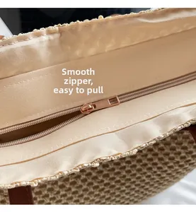 Close-up of smooth gold-tone metal zipper and fabric lining on a woven straw tote bag