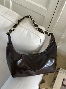 Deep brown glossy leather hobo shoulder bag with elegant gold chain and crescent shape
